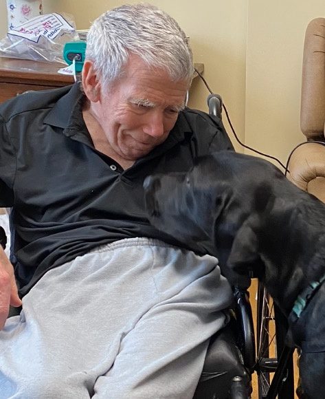 Senior man smiling while looking his dog
